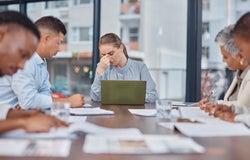 Business people, team and woman with headache in meeting at office, mistake and fail. Stress, group and person frustrated in problem, financial crisis or fear for challenge of tax debt in bankruptcy.